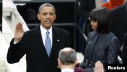 U.S. President Barack Obama is sworn in by Supreme Court Chief of Justice John Roberts, as first lady Michelle Obama looks on during inauguration ceremonies in Washington, D.C., January 21, 2013.