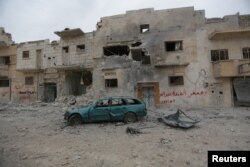 A damaged vehicle is seen near buildings in the northern Syrian town of al-Bab, Syria, March 1, 2017.