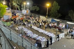 Pejabat keamanan dan regu penyelamat Israel berdiri di sekitar mayat korban yang meninggal dalam perayaan Lag Ba'Omer di Mt. Meron, Israel utara, Jumat, 30 April 2021.