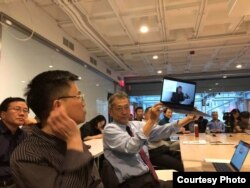 哈佛大学"改革开放40年：挑战和机遇"系列研讨，无法到场的天则经济研究所所长盛洪教授的视频发言，学者吴思举着电脑播放视频（盛洪推特照片）