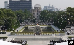 FILE - In this Aug. 6, 2013 file photo, doves fly over the cenotaph dedicated to the victims of the atomic bombing at the Hiroshima Peace Memorial Park during a ceremony marking the 68th anniversary of the bombing, in Hiroshima, western Japan.