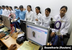 Para pekerja migran tujuan negara-negara Timur Tengah difoto untuk pembuatan paspor di kantor imigrasi Tangerang, Banten, 23 Juni 2011. (Foto: Beawiharta/Reuters)