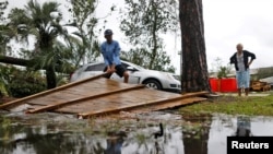 Joseph Howat clears a damaged fence by Hurricane Michael at his business in Panama City Beach, Florida, U.S. October 10, 2018. (REUTERS/Jonathan Bachman)