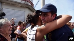 Governor Ricardo Rossello receives a hug from a resident after the arrival of National Guard at Barrio Obrero to distribute water and food among those affected by Hurricane Maria, in San Juan, Sept. 24, 2017.