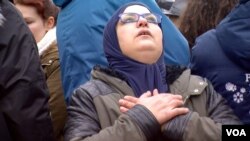 A woman mourns as hundreds of people gather at the Place de la Bourse in downtown Brussels following the terrorist attacks that left dozens of people dead, March 23, 2016. (L. Bryant/VOA)