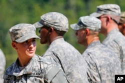 Kapitan Kristen Grist (chapda) safdoshlari bilan