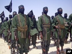 FILE - A February 2011 photo shows al-Shabab fighters on parade with their guns during military exercises on the outskirts of Mogadishu,Somalia.