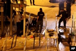 Israeli police officers dismantle metal detectors outside the al-Aqsa Mosque compound in Jerusalem's Old City, July 25, 2017.