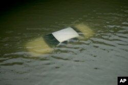 A car is submerged on a freeway flooded by Tropical Storm Harvey, Aug. 27, 2017, near downtown Houston, Texas.
