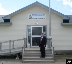 FILE - Gander, Newfoundland, Canada Mayor Claude Elliott stands in front of the Royal Canadian Legion Hall. At this remote town with a population of about 10,000 and an international airport built before World War II, 38 planes carried in 6,600 passengers landed after the September 11 attacks.