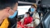 People wear masks on a bus in Quang Ninh province, Vietnam, Jan. 28, 2018. A tourism company director in Vietnam says the coronavirus outbreak that began in China has hit his industry “very hard, like a giant bomb."
