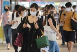 28일 일본 도쿄 기차역에서 마스크를 쓴 사람들.