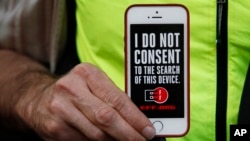 A man holds up his iPhone during a rally in support of data privacy outside an Apple store in San Francisco, Calif., Feb. 23, 2016. Protesters lashed out at a government order requiring Apple to help unlock an encrypted iPhone.