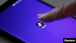 The logo of the TikTok application is seen on a mobile phone screen.