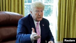 FILE - U.S. President Donald Trump speaks during a Good Friday event for Easter in the Oval Office at the White House in Washington, April 10, 2020.