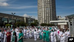 Para petugas medis mengheningkan cipta untuk dr. Joaquin Diaz, yang meninggal akibat Covid-19, di Madrid 20 April 2020.