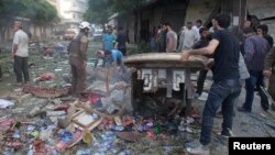 People inspect the damage at a market hit by airstrikes in Idlib city, Syria, June 5, 2016. 