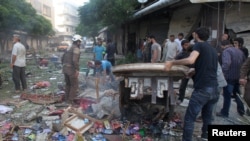 Warga memeriksa kerusakan di sebuah pasar yang terkena serangan udara di Idlib, Suriah (5/6). 