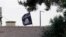 FILE - An Islamic State flag flies over the customs office of Syria's Jarablus border gate, Aug. 1, 2015. A Maryland man has been detained on federal charges in connection with the IS group.