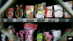 Kondom terlihat di atas rak permen karet dan makanan ringan di mesin penjual otomatis di China, 23 September 2007. (Foto: AP)