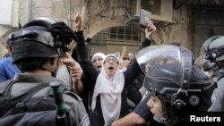 Israeli police prevent a Palestinian women from entering the compound which houses al-Aqsa mosque, in Jerusalem's Old City, Sept. 13, 2015.