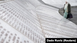 Bosnia and Herzegovina, A woman is seen near a grave of her family members in the Memorial centre Potocari 