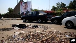 Cars drive between brick barricades erected along a street that leads to Rabaah al-Adawiya mosque, where supporters of Egypt's ousted President Mohammed Morsi have installed a camp and hold daily rallies at Nasr City, in Cairo, July 29, 2013. 
