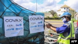 FILE - A worker handles boxes of COVID-19 vaccines, delivered as part of the COVAX equitable vaccince distribution program, at Ivato International Airport, in Antananarivo, Madagascar, May 8, 2021. 
