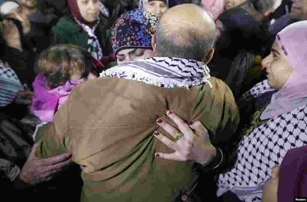 A prisoner released from an Israeli prison (C, back to camera) is welcomed by relatives in Ramallah, West Bank, Dec. 31, 2013.&nbsp;