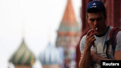 FILE - A man smokes a cigarette at Moscow's Red Square.