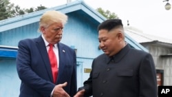 แฟ้ม - ผู้นำสูงสุดของเกาหลีเหนื คิม จอง อึน จับมือกับประธานาธิบดีโดนัลด์ ทรัมป์ ที่เขตปลอดทหาร หมู่บ้านปันมุนจอม เกาหลีใต้ 30 มิ.ย. 2019 (AP Photo/Susan Walsh, File)