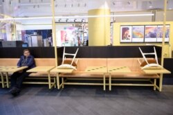 A woman sits respecting social distancing at the Gallerian shopping center, as the spread of the coronavirus disease continues, in Stockholm, Sweden, May 12, 2020.