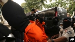 Police anti-terror unit escort suspected militants before a press conference in Jakarta, May 17, 2019. Police say they have arrested suspected militants following a tipoff about a possible attack during the announcement of presidential election results next week.