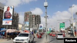 Motorists drive past the campaign billboard of Somalia's opposition presidential candidate Abdirahman Abdishakur Warsameh along the main streets of Mogadishu, Somalia, Feb. 8, 2021.