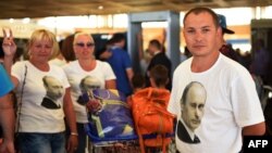 Russian tourists wearing t-shirts bearing a portrait of Russian President Vladimir Putin, queue inside the airport in Egypt's Red Sea resort of Sharm El-Sheikh on Nov. 6, 2015. Russia has halted all flights to Egypt. AFP PHOTO / MOHAMMED EL-SHAHED