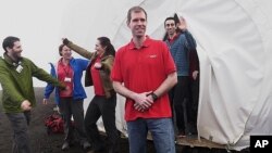 In this photo provided by the University of Hawaii, six scientists celebrate as they exit from their Mars simulation habitat on slopes of Mauna Loa on the Big Island, Hawaii, Sunday, Aug. 28, 2016. The scientists completed a yearlong Mars simulation in Hawaii on Sunday, where they lived in the dome in near isolation. (University of Hawaii via AP)