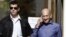Former Israeli Prime Minister Ehud Olmert (R) speaks on the phone as he leaves the Jerusalem District court, September 24, 2012.