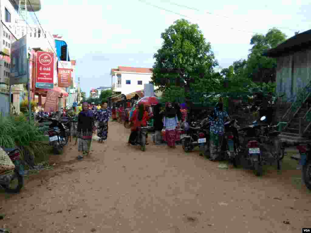 អ្នកភូមិចេញចូលទៅមកផ្សារព្រែកចាម ពេលព្រឹក ក្នុងភូមិស្វាយឃ្លាំង ឃុំស្វាយឃ្លាំង ស្រុកក្រូចឆ្មារ ខេត្តកំពង់ចាម នៅថ្ងៃអាទិត្យ ទី២៣ ខែកក្កដា ឆ្នាំ២០១៧។ (សើ សាយ្យាណា/VOA)