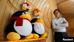 FILE - Tencent Chairman and CEO Pony Ma poses with mascots for QQ.com in 2011. Two chatbots, BabyQ and XiaoBing, on Tencent's messaging service, QQ were taken offline after making politically sensitive remarks. (Reuters/Bobby Yip)