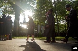FILE - Graduates walk at a Harvard Commencement ceremony held for the classes of 2020 and 2021, May 29, 2022, in Cambridge, Mass. (AP Photo/Mary Schwalm, File)