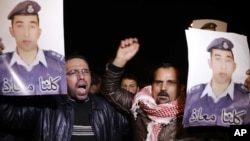 People from the al-Kaseasbeh tribe and other tribes take part in a demonstration outside of Jordan's cabinet in Amman calling for the release of Jordanian pilot Lt. Mu'ath al-Kaseasbeh, who is held by Islamic State group militants, Jan. 27, 2015.