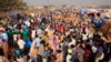 Displaced people walk around Tomping camp in Juba, where some 15,000 people who fled their homes are sheltered by the United Nations, Jan. 7, 2014. 
