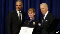 Vice President Joe Biden and Attorney General Eric Holder present the Medal of Valor to Officer Julie Olson of the Maplewood, Minnesota, Police Department, during a ceremony in the Eisenhower Executive Office Building on the White House complex in Washing