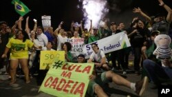 Demonstrators against Brazil's former President Luiz Inacio Lula da Silva celebrate Supreme Court justices' votes as they are made public outside the National Congress in Brasilia, Brazil, April 4, 2018. The sign says in Portuguese: "Lula in prison!" 
