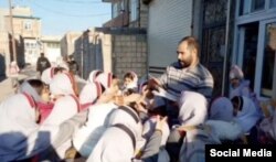 Müctəba Əbdüli məktəbli uşaqlara kitab paylarkən