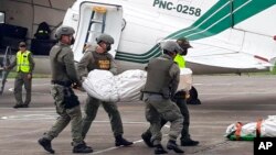 پولیس کولمبیا جسد یکی از سه کارمند مطبوعاتی را که در منطقهٔ مرزی با اکوادور اختطاف و کشته شده بودند، حمل می کنند.
