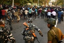 Security personnel use batons to disperse students protesting against the government's Citizenship Amendment Bill, in Guwahati, Dec. 11, 2019.