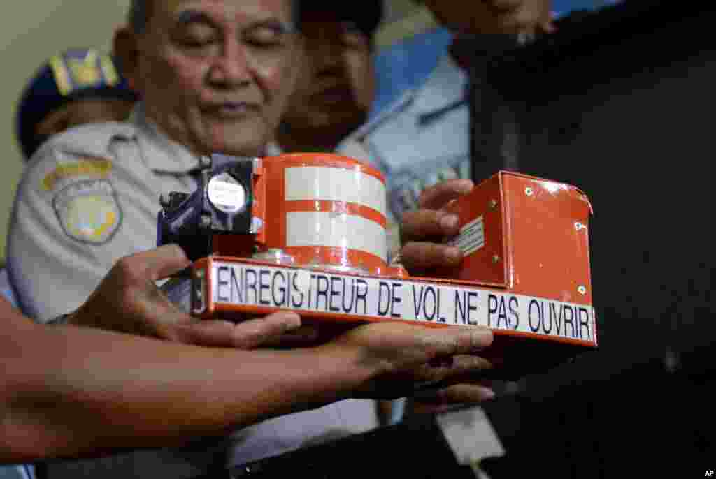 Head of Indonesian National Transportation Safety Committee Tatang Kurniadi (center) shows the newly recovered cockpit voice recorder from the ill-fated AirAsia Flight 8501 during a press conference in Pangkalan Bun, Central Borneo, Indonesia, Jan. 13, 2015.