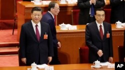 Wang Qishan, former secretary of the Central Commission for Discipline Inspection, walks past Chinese President Xi Jinping and Chinese Premier Li Keqiang (R) at the opening session of the National People's Congress (NPC) at the Great Hall of the People in Beijing, China, March 5, 2018. 