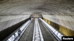 People descend on the escalator at the Bethesda Metro train station during commuter rush hour in Bethesda, Maryland, after Maryland Governor Larry Hogan ordered the shutdown of all bars and eateries in the state due to the coronavirus, March 16, 2020.